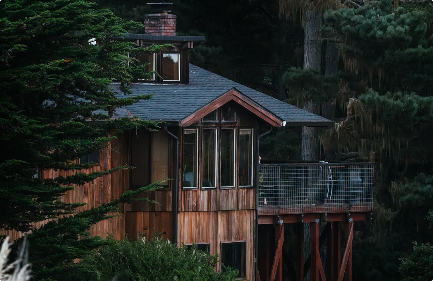 Timber cabin with a balcony among tall pines