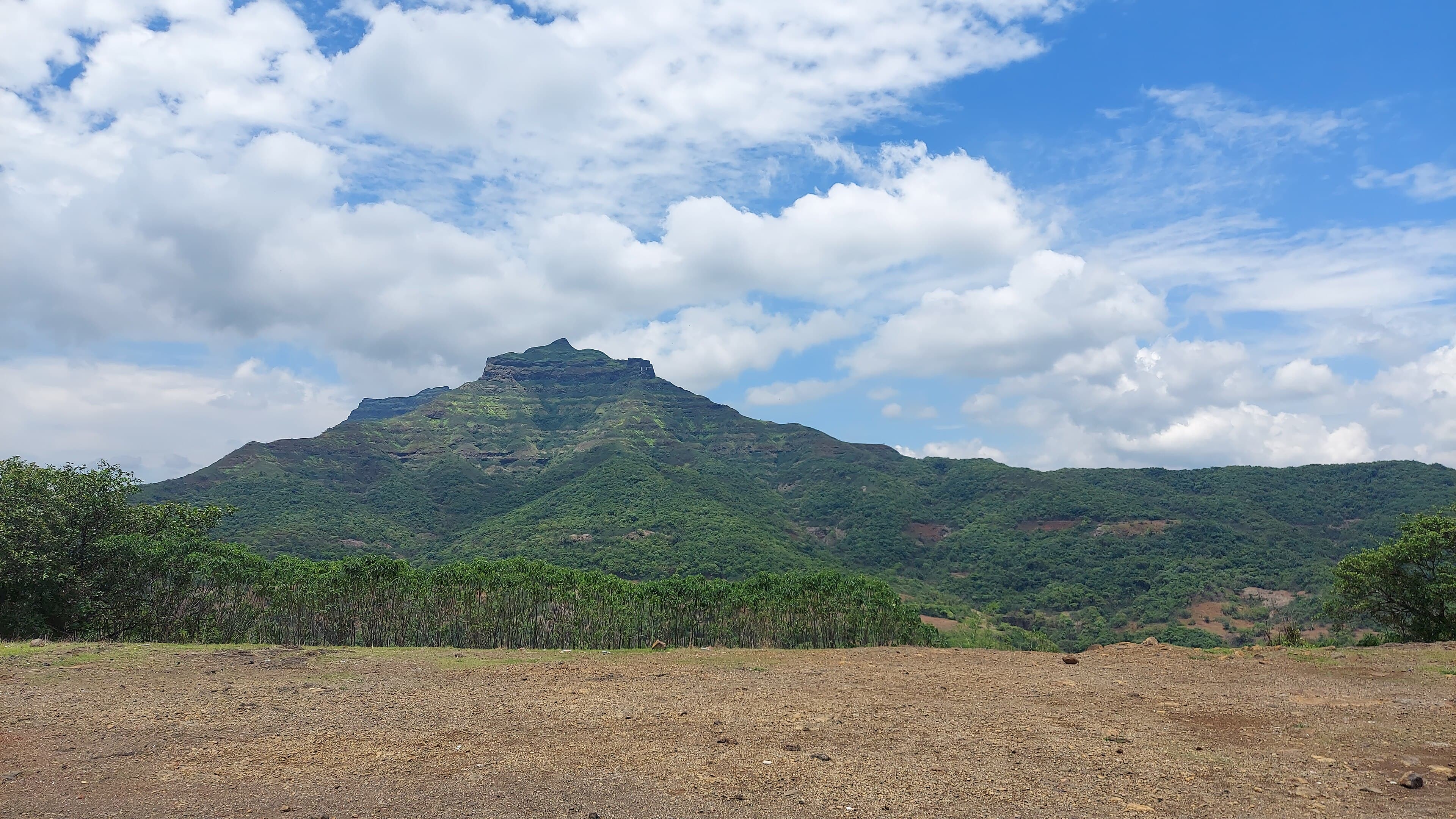 Cleared open ground with the Torna hills rising behind