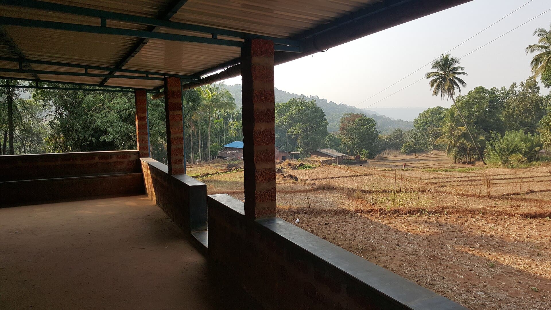 Brick-built house with a veranda overlooking farmland and hills